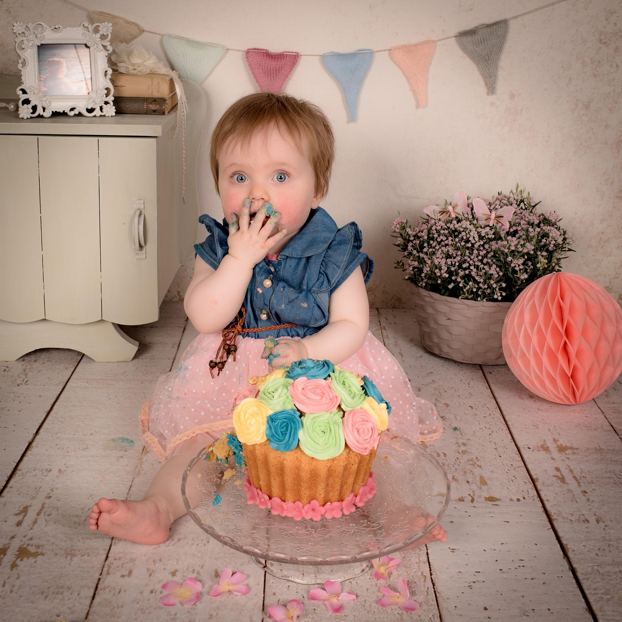 A decorated first birthday smash cake